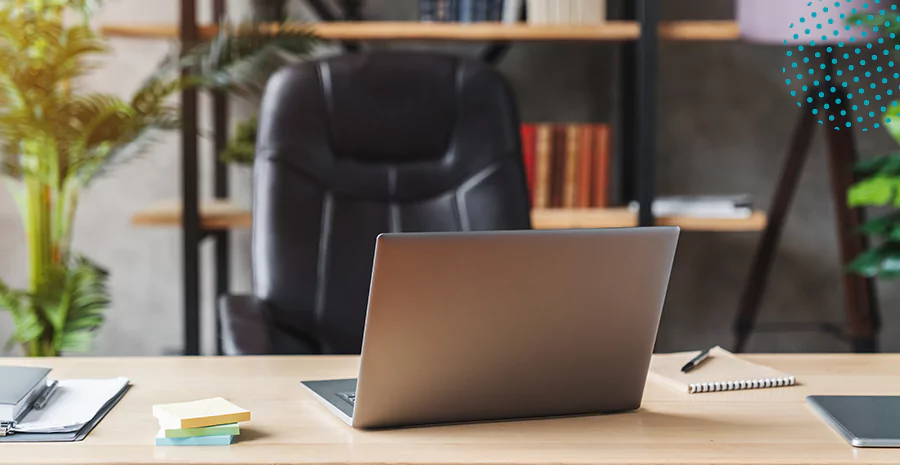 imagem de uma mesa com notebook em cima e uma cadeira