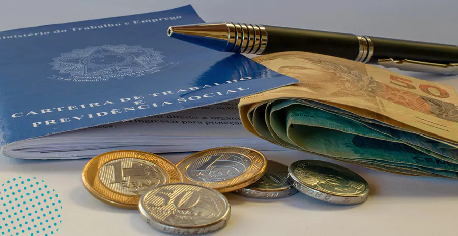Carteira de Trabalho acompanhada de notas e moedas de real, simbolizando direitos trabalhistas e a aplicação do Artigo 473 da CLT para faltas justificadas.